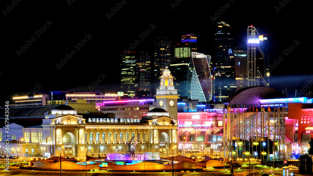downtown moscow city at night modern architecture landmark with Kievskaya railway station at Europe square against business financial district skyscrapers background. Street view. Wide panorama downtown moscow city at night modern architecture landmark with Kievskaya railway station at Europe square against business financial district skyscrapers background. Street view. Wide panorama