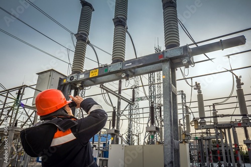 ULYANOVSK, RUSSIA - SEPTEMBER 27, 2018: Engineer is helmet looks through binoculars at manometer checking gas pressure at electric power station.