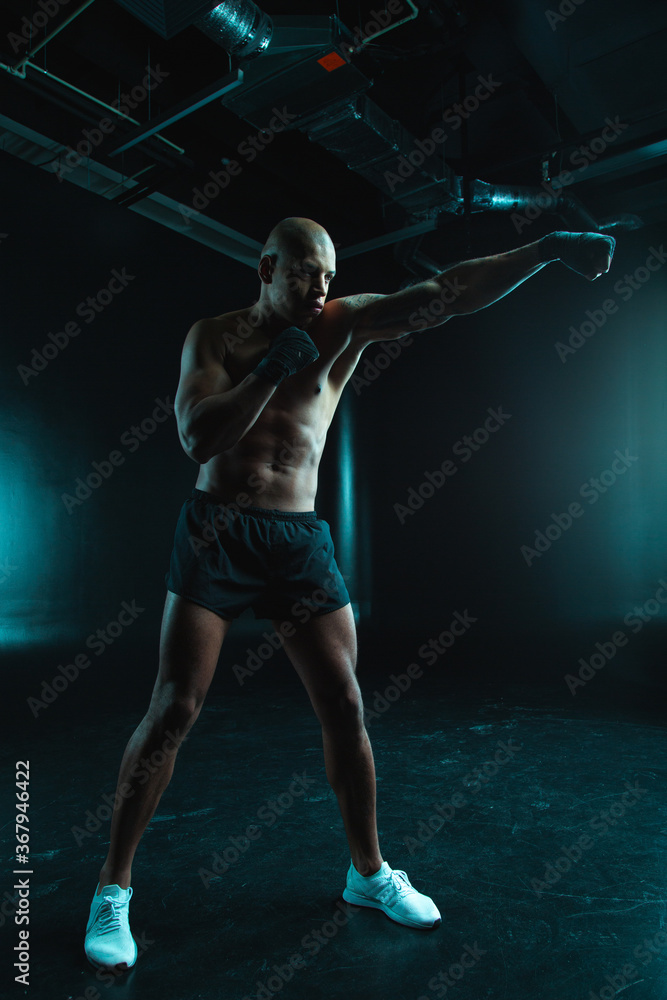 Confident man training boxing stance while being alone Confident man training boxing stance while being alone
