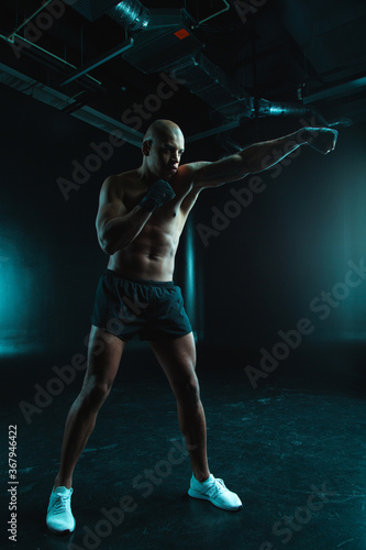 Confident man training boxing stance while being alone