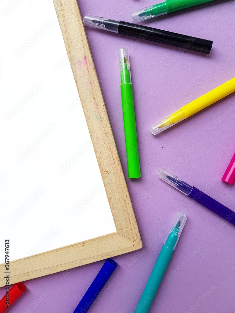 Empty clean white sheet for the buyer's text on the purple background and school supplies, pencils. Back to school. Empty clean white sheet for the buyer's text on the purple background and school supplies, pencils. Back to school.