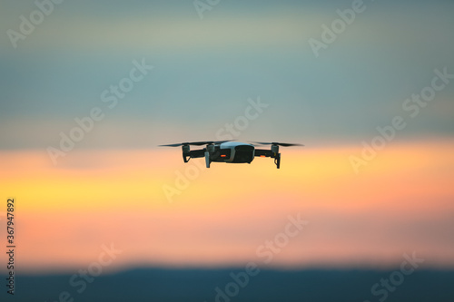 Drone pilotage on the sky at sunset.