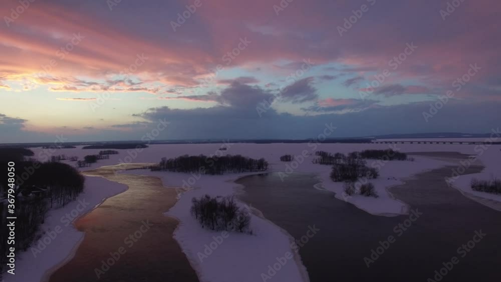 Stunning sunset making clouds purple viewed by flying drone in winter scenery Stunning sunset making clouds purple viewed by flying drone in winter scenery