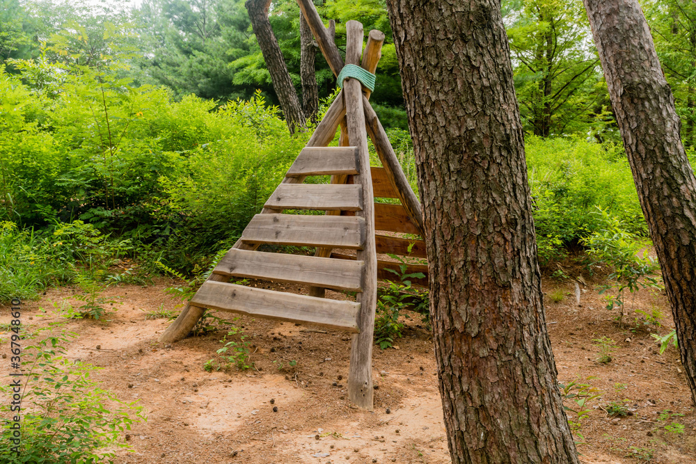 Wooden teepee shaped climbing apparatus.