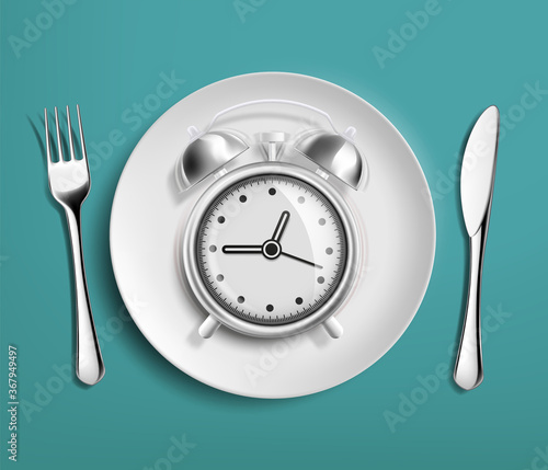 Alarm clock in an empty plate. Diet and nutrition