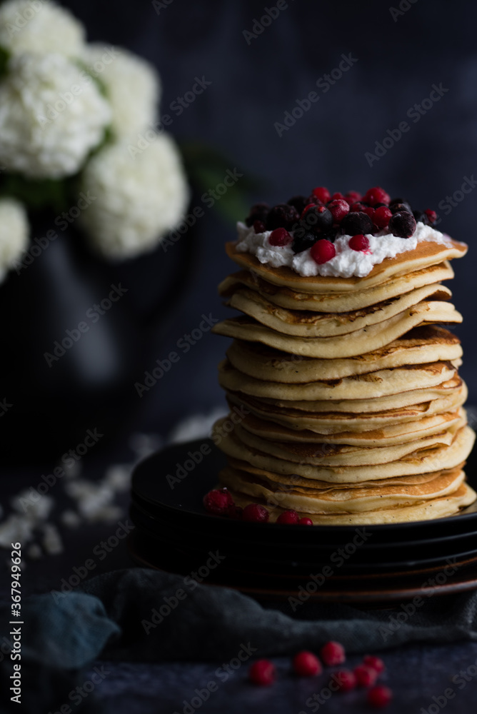 Stack of pancakes with blueberries and maple syrup for breakfast