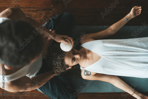 Masseur doing massage female face with rubber ball. photo