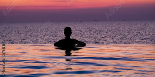 Wallpaper Mural Swimming in sunset sunrise. Man swimming in infinity pool. Copy space banner. Hotel business, travel concept, travelling Torontodigital.ca
