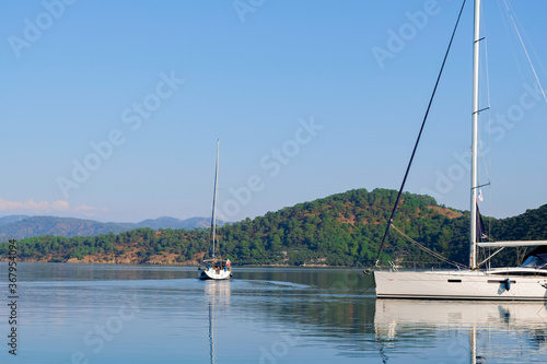 Racing yacht in the sea on blue sky background. Peaceful seascape. Beautiful blue sky over calm sea.