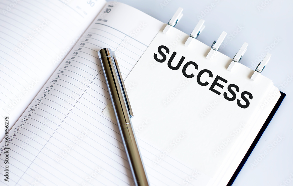 text SUCCESS on the short note texture background with pen text SUCCESS on the short note texture background with pen