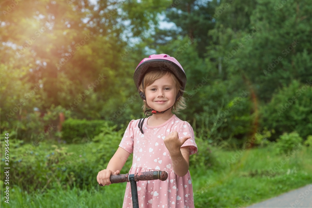 Portrait of active little toddler girl riding scooter on a village road Portrait of active little toddler girl riding scooter on a village road