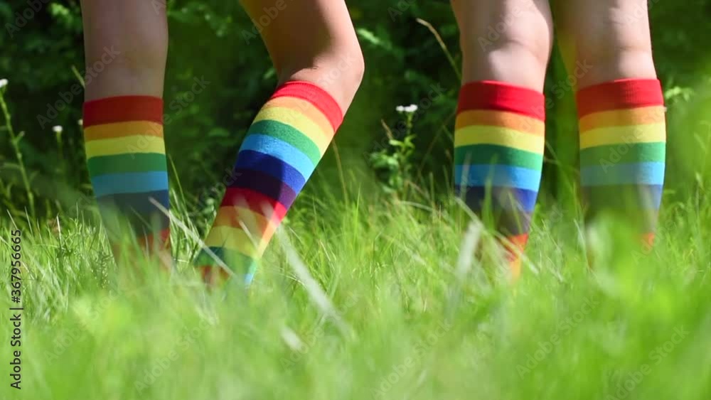 children girl and boy in rainbow striped socks playing in the street on the grass children girl and boy in rainbow striped socks playing in the street on the grass