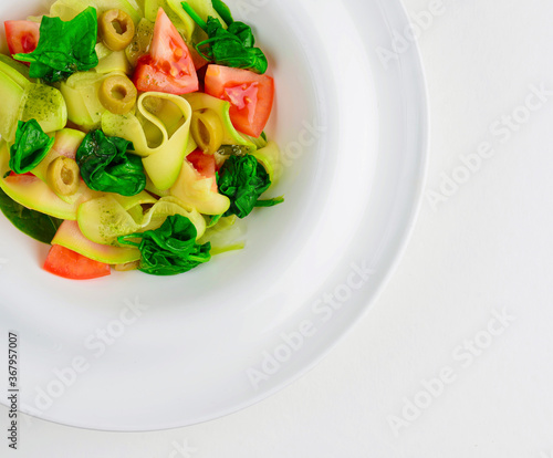 Vegetable pasta penne with asparagus,tomato and rucola in a white bowl. Close up. Copy space for text.