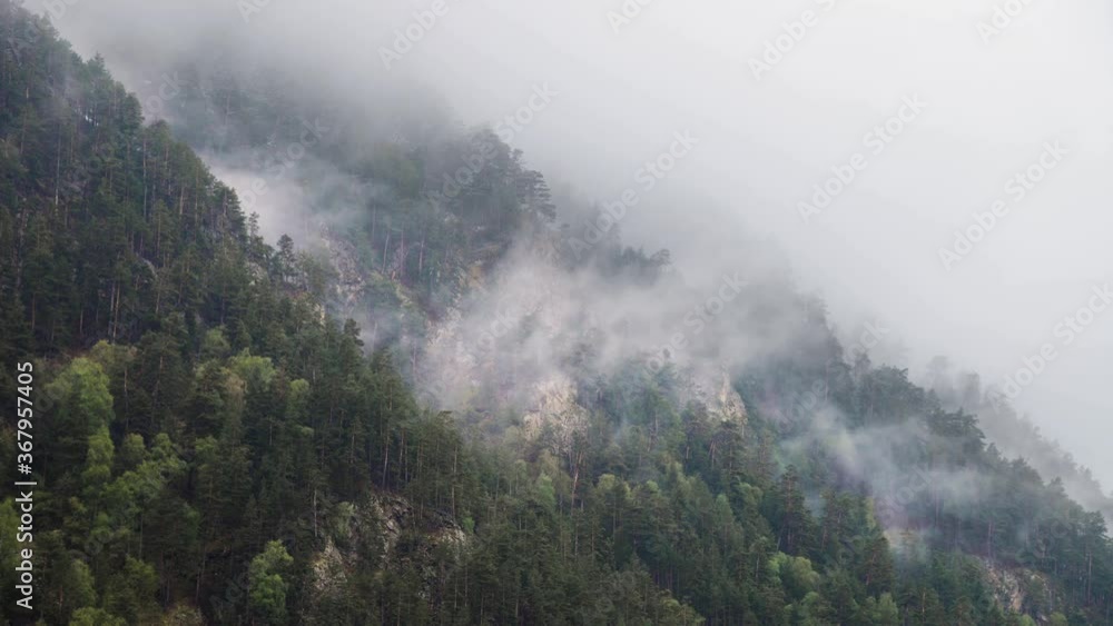 Taillaps steep mountain slopes covered with eternally green forest and powdered with snow on which low clouds flow. 4K cloud movement in the mountains Taillaps steep mountain slopes covered with eternally green forest and powdered with snow on which low clouds flow. 4K cloud movement in the mountains