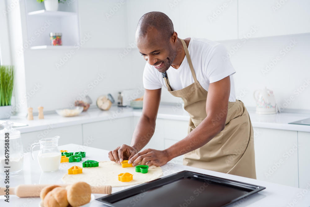Portrait of his he nice attractive cheerful cheery focused guy making handmade pie cake using form shape holiday day easter having fun in modern light white interior house kitchen