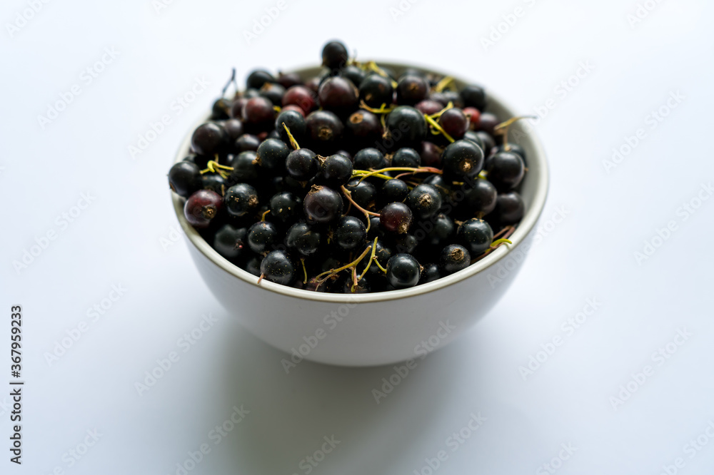 Fresh ripe berries black currants in a white plate Fresh ripe berries black currants in a white plate