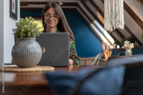 Obraz na plátně Young woman watching funny content on her lap top compter