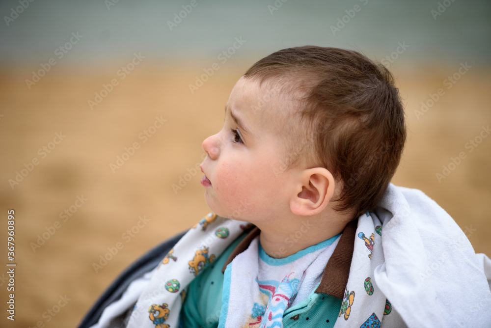 Portrait of a cute baby boy on the beach on a summer day. Outdoors, close-up. Portrait of a cute baby boy on the beach on a summer day. Outdoors, close-up.