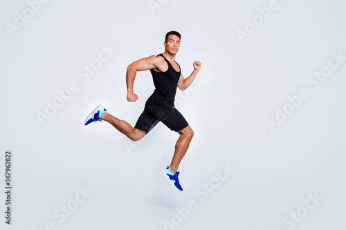 Full length body size view of his he nice attractive strong sportive muscular guy jumping running fast goal cup champion jogging sprinter isolated over light gray pastel color background