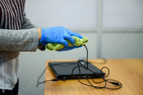 Treatment of laptop and mouse with antiseptic-hands in gloves close-up © kulkann