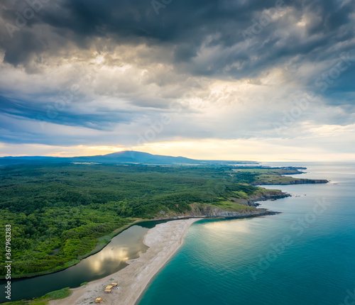 An empty wild beach, surrounded by rocks and green thick forests. Aerial view with beautiful, wild beach at the Black Sea coast and the estuary of Veleka river, Bulgaria.