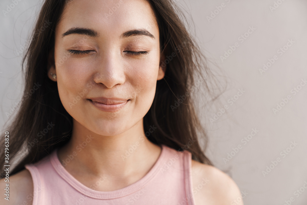 Image of joyful asian beautiful girl smiling with eyes closed Image of joyful asian beautiful girl smiling with eyes closed