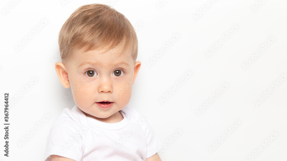 Caucasian curly brown-eyed baby boy in a white T-shirt on a white background