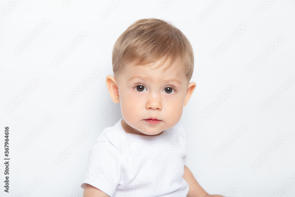 Caucasian brown-eyed baby boy in a white T-shirt on a white background