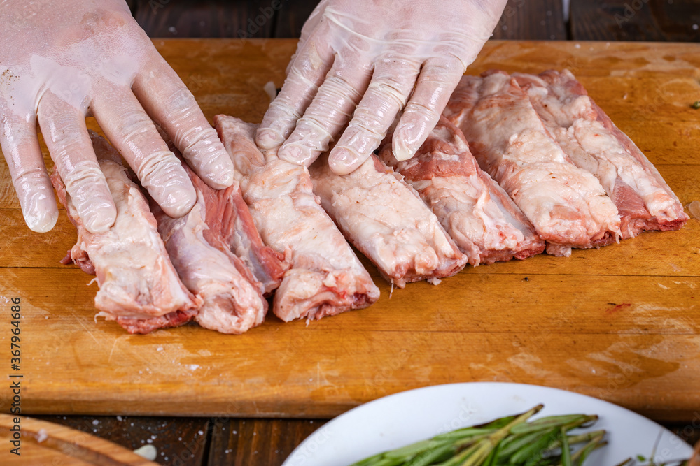 Preparation and cooking of pork ribs by a chef for a grill.