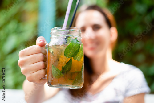 Woman drinking mint cocktail at beach bar in vacation.