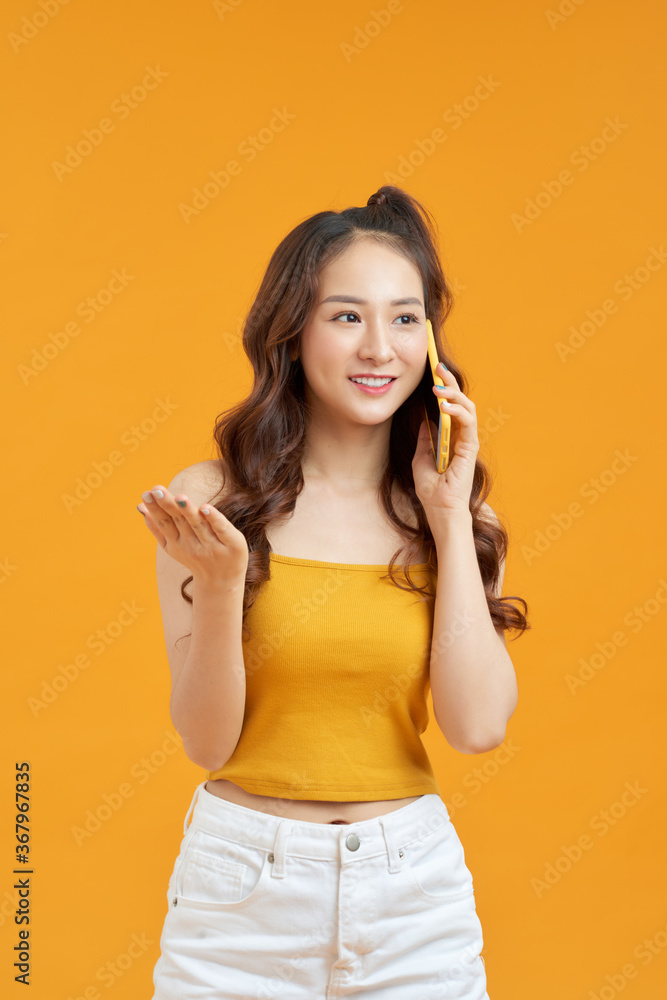 Cheerful Asian teenage girl laughing while talking on cellphone, Cheerful Asian teenage girl laughing while talking on cellphone,