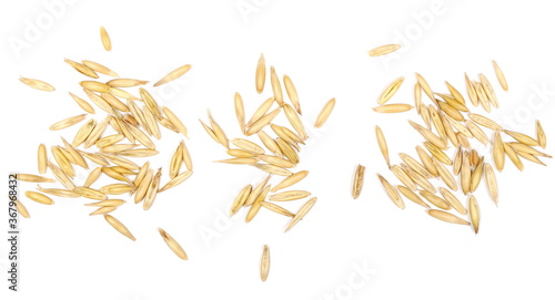 Unpeeled oat grains, piles isolated on white background, top view