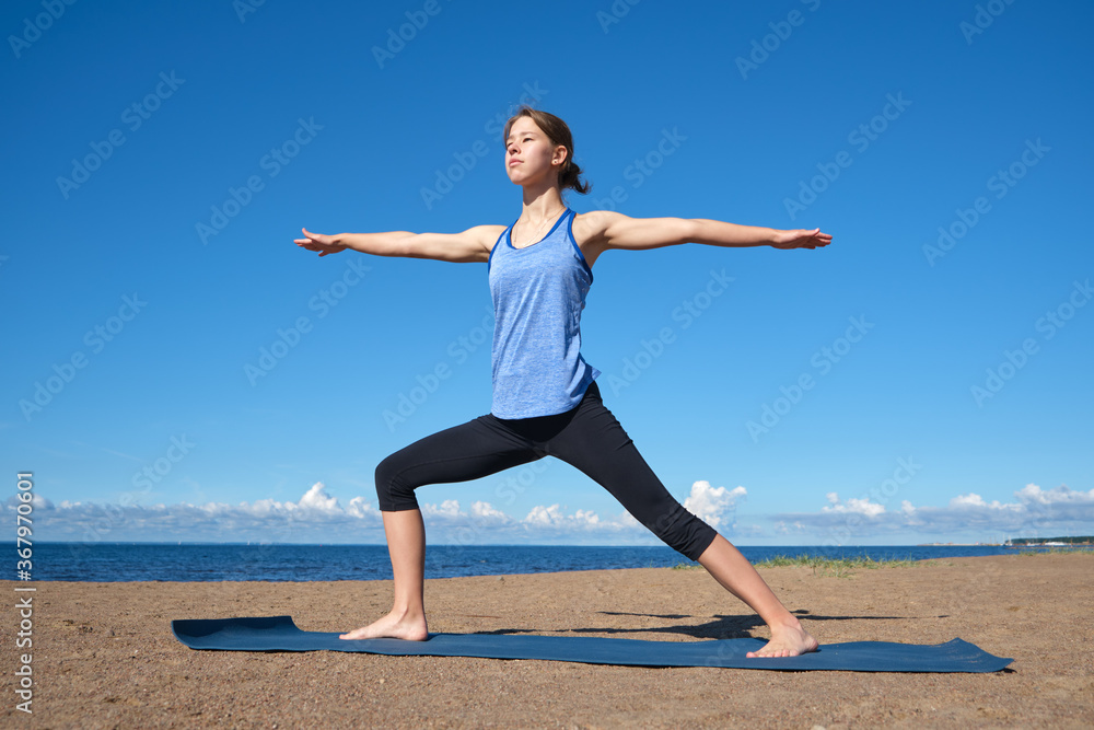 Young slim girl doing yoga on the beach on a sunny morning Young slim girl doing yoga on the beach on a sunny morning