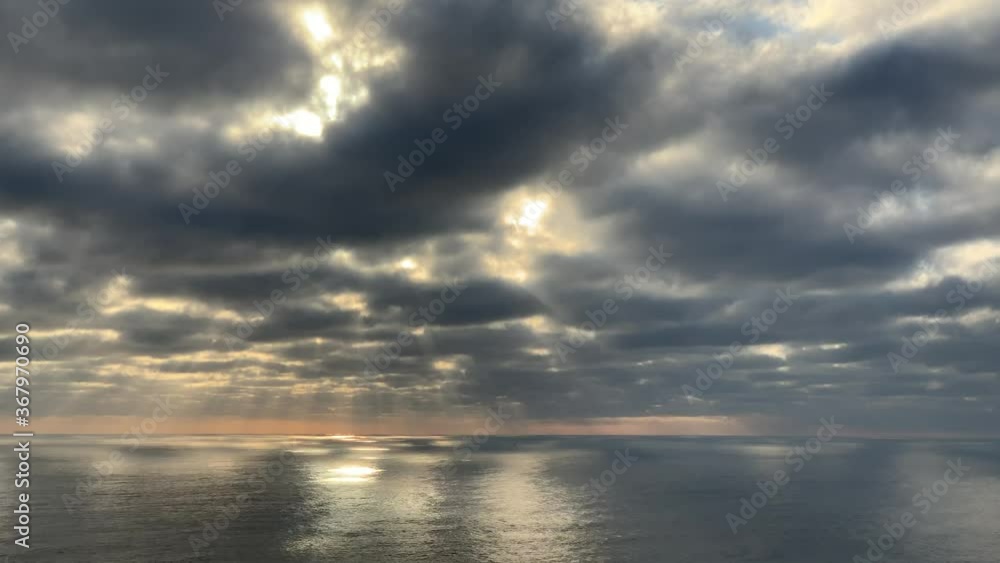Sunset rays penetrating the grey clouds reflecting it’s soft rays on the Atlantic Ocean on the Cape Peninsula Sunset rays penetrating the grey clouds reflecting it’s soft rays on the Atlantic Ocean on the Cape Peninsula