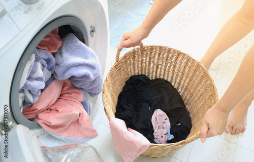 Foto Woman carried a laundry basket in the washing machine and the washing machine is full of clothes that need cleaning
