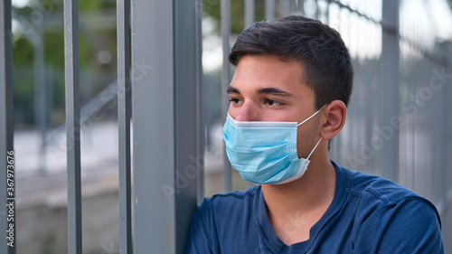 Young teen boy wearing face mask outdoor due to the Coronavirus Pandemic