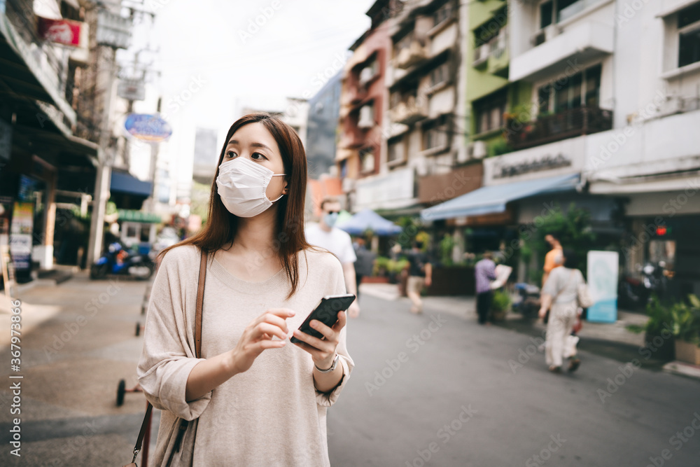Fototapeta premium Business young asian single woman wear mask for corona virus or covid19 at city outdoor