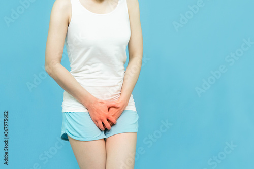 low body of a woman in white tank top put her hands on crotch pants area mark red at spot of ache,  Itching urinary or penis pain Health-care concept on white background