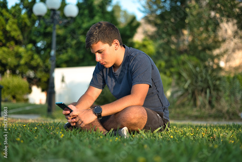 Teenage Boy Using Phone In Urban Setting