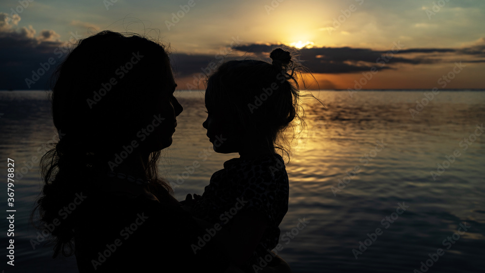 young couple mother and little kid posing on beach sunset 