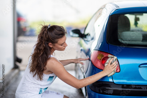 Woman wash her car in self service car wash