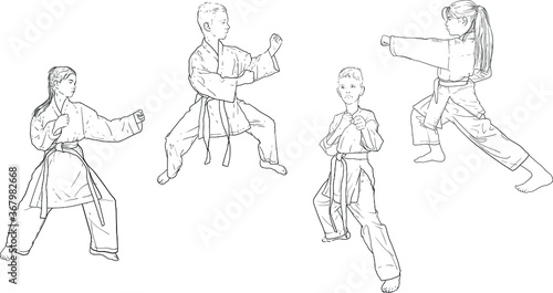 boys and girls in white kimonos practice karate standing in a fighting stance