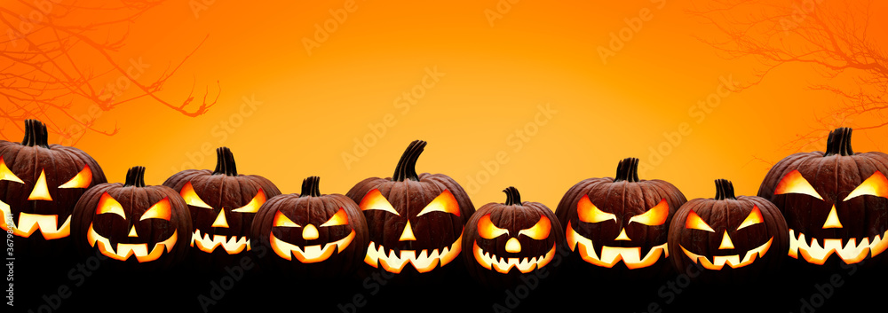 Nine halloween, Jack O Lanterns, with evil spooky eyes and faces isolated against a orange and yellow lit background.