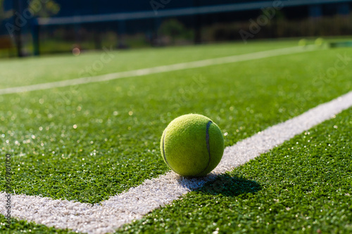 View of empty lawn tennis court with tennis ball