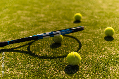 Green ball falling on floor nearly white lines of outdoor tennis court in public park