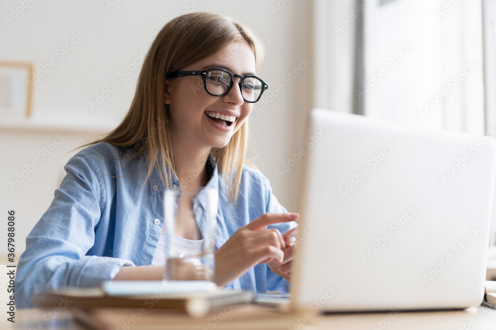 Young woman having video call via laptop at home