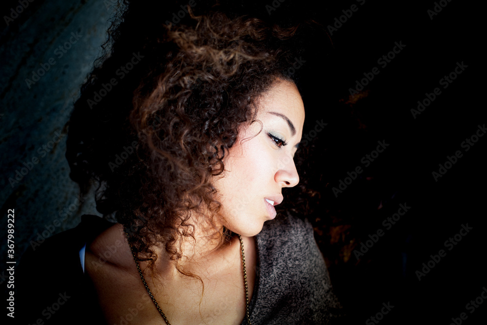 an attractive afro American girl in a relaxation pose looking away 
