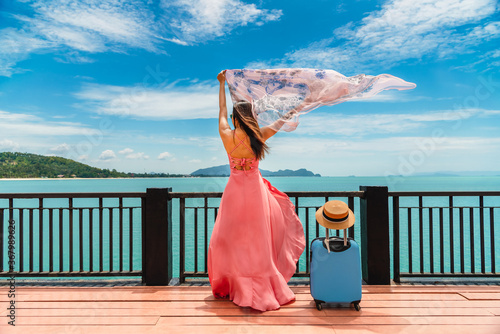 Bild auf Leinwand Happy joyful traveler woman in dress waving fabric at wood pier on sea shore, At