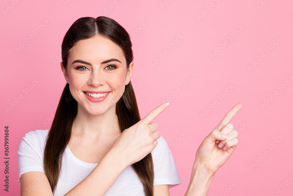 Closeup photo of pretty funny lady long hairdo tails directing finger side empty space demonstrating novelty product wear casual white t-shirt isolated pastel pink color background Closeup photo of pretty funny lady long hairdo tails directing finger side empty space demonstrating novelty product wear casual white t-shirt isolated pastel pink color background