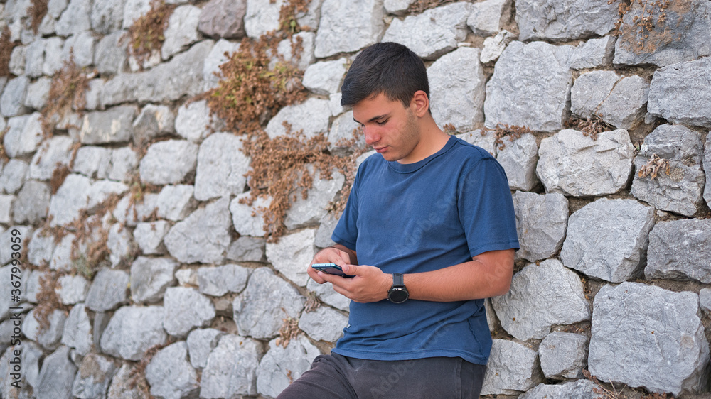 Teenage Boy Using Phone In Urban Setting Teenage Boy Using Phone In Urban Setting